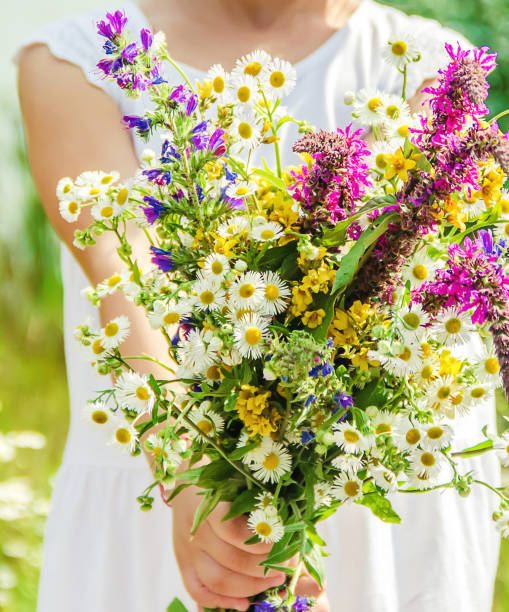 istock Child with a bouquet of wildflowers. Selective focus. 1148761438