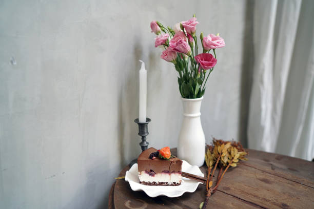 Homemade Black Forest Mousse Cake mixed with mascarpone cheese and topped with fresh strawberry, mulberry on wooden table and blurred background.