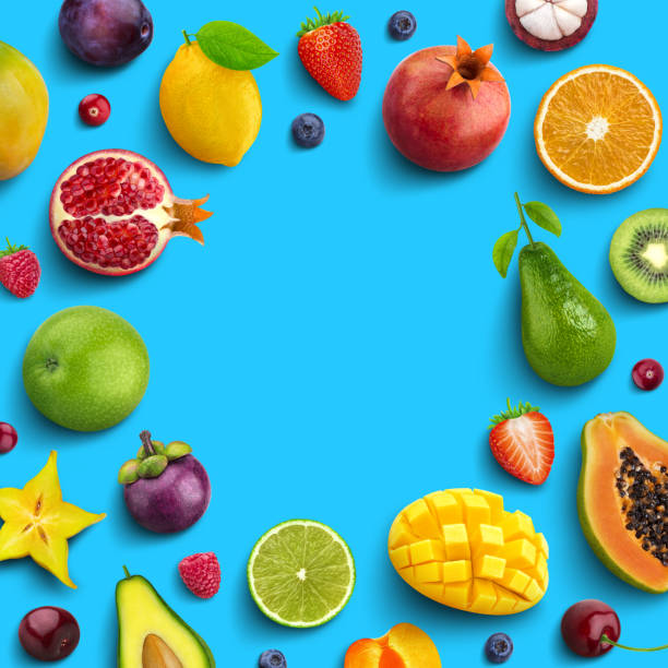 istock Various fruits and berries isolated on blue background, top view, creative flat layout, round frame of fruits with empty space for text 1148766689