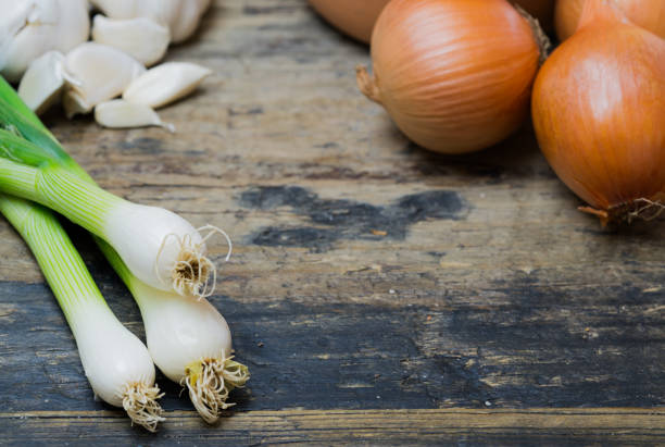 istock spring onions garlic and brown onions on a rustic wooden table 1148767836