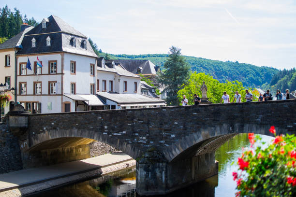 View of the Our river with a stone bridge in the old town of Vianden, Luxembourg, with typical houses at the background View of the Our river with a stone bridge in the old town of Vianden, Luxembourg, with typical houses at the background vianden stock pictures, royalty-free photos & images