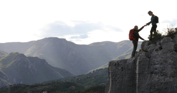 istock Female hikers climb to mountain summit at sunrise 1148769372