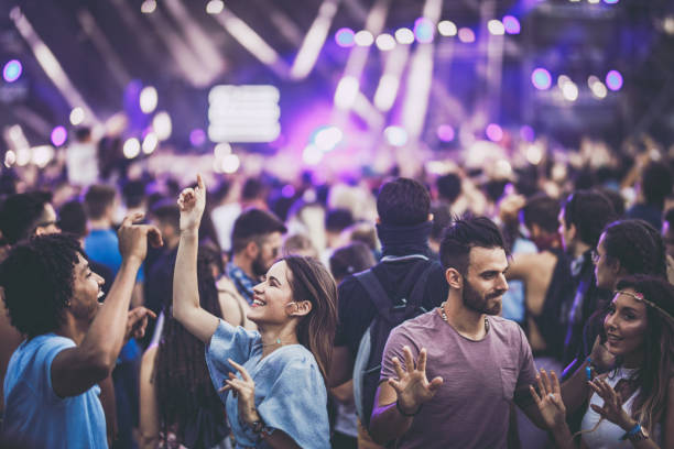 Young happy people having fun while dancing on a music festival.