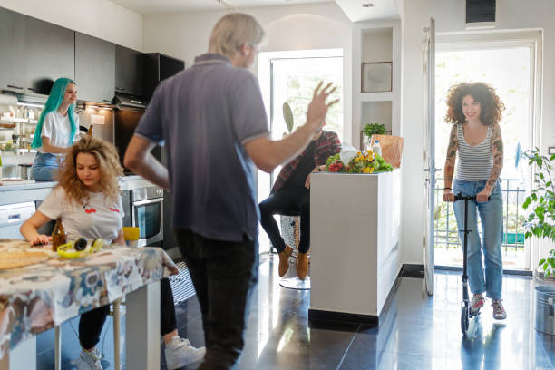 istock Flatmates welcoming friend entering home on scooter 1148769554