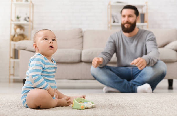 istock Father playing with his baby son on floor at home 1148772284