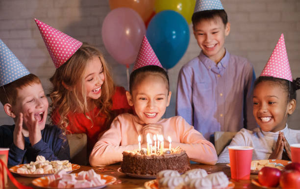 istock Happy children looking at birthday cake with candles 1148772311