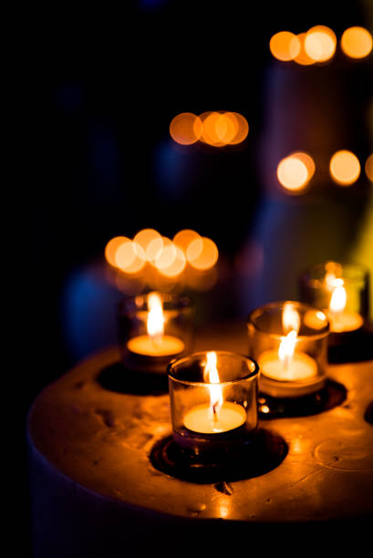 istock Flame of many candles burning on blurred lights background. 1148776433