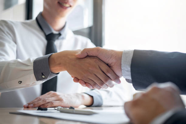 istock Midsection Of Manager And Candidate Shaking Hands At Interview On Table 1148779359