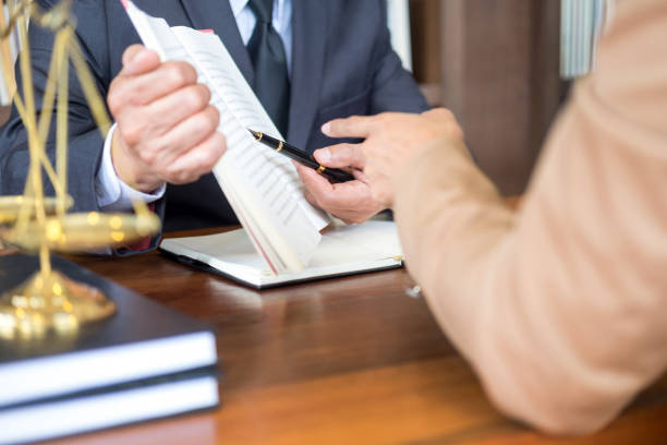 istock Midsection Of Man And Lawyer Discussing While Sitting On Table 1148779394