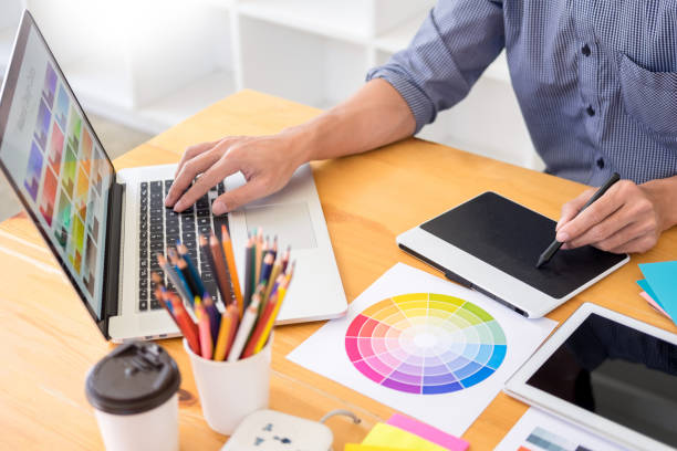 istock Midsection Of Man Using Laptop And Graphics Tablet At Creative Office 1148780565