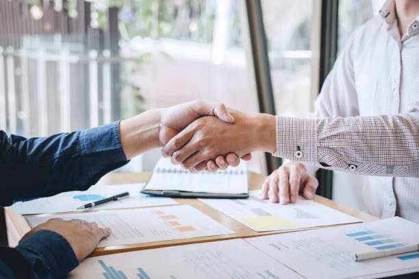 istock Midsection Of Businessmen Shaking Hands On Table 1148784102