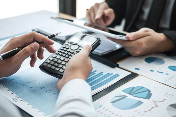 istock High Angle View Of Businessmen Working Over Graph On Table 1148784579