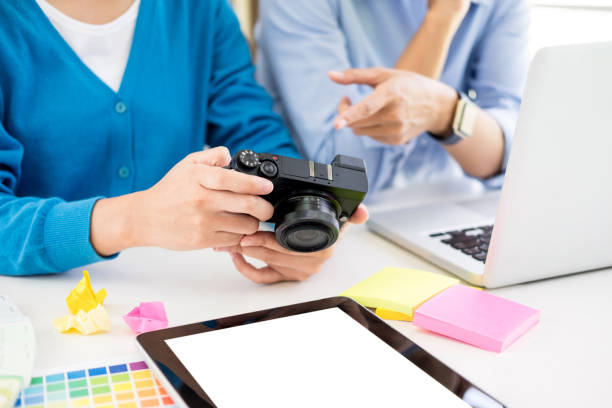 istock Midsection Of Design Professionals Holding Camera On Table 1148785444