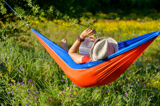 Woman reading book in hammock.