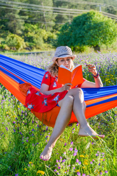 istock Woman reading book in hammock. 1148788653