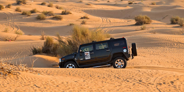 DUBAI, UNITED ARAB EMIRATES - JANUARY 25, 2016: Safari Hummer vehicle drives rally off-road car 4x4 adventure sand desert landscape, UAE, Dubai.