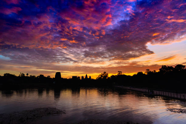 istock Angkor Wat dramatic sky at dawn main facade silhouette reflection on water pond. World famous temple in Cambodia. 1148791543