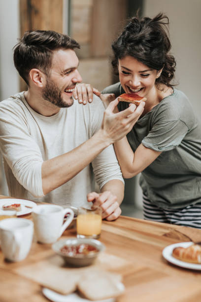 istock Happy man feeding his girlfriend during breakfast time at home. 1148792093