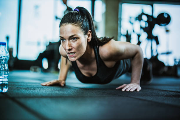 istock Determined athletic woman exercising push-ups in a gym. 1148793413