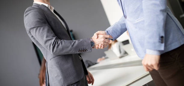istock Two confident business man shaking hands during a meeting in the office 1148794847