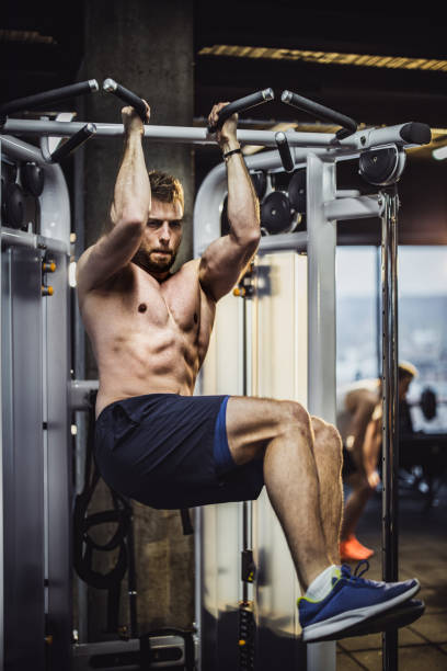 istock Muscular build man exercising abdominal muscles on a machine in a gym. 1148795092