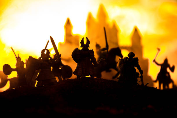 istock Medieval battle scene with cavalry and infantry. Silhouettes of figures as separate objects, fight between warriors on sunset foggy background. 1148795367
