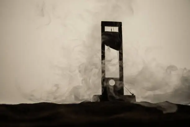 Horror view of Guillotine. Close-up of a guillotine on a dark foggy background. Execution concept