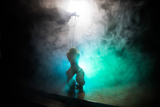 istock Concept of manipulation. Hand holds strings for manipulation. The hand controls the puppet strings on a dark foggy background. 1148795484