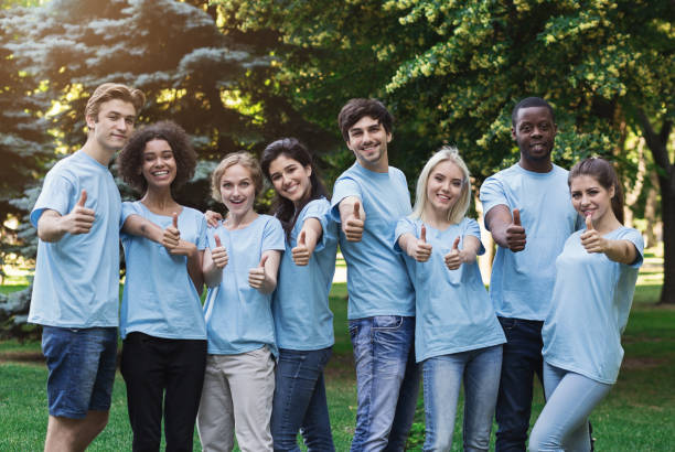 istock Confident young volunteers gesturing thumbs up at park 1148796646