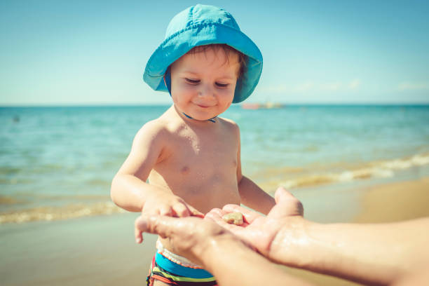 Happy child having fun near the sea with his parent