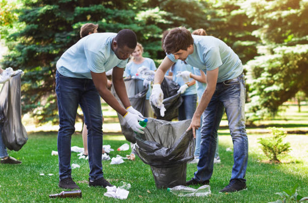 istock Optimistic volunteers holding garbage bag in park 1148796686