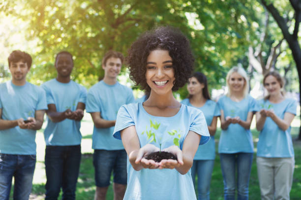 成長のための木を持つボランティアのグループ - planting tree human hand women ストックフォトと画像