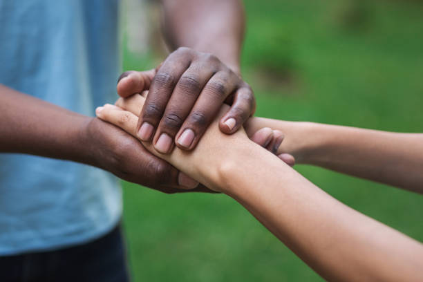 istock Black caregiver supporting woman hand in park 1148796706
