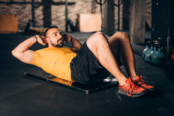 istock Strong athletic man doing a sit ups exercise in a gym 1148796936