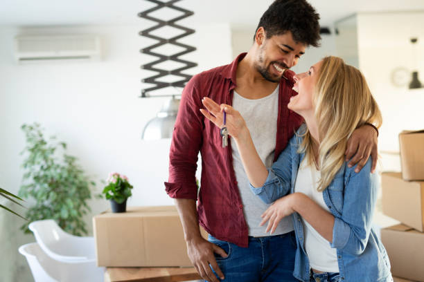 istock Young married couple with boxes and holding flat keys 1148796978