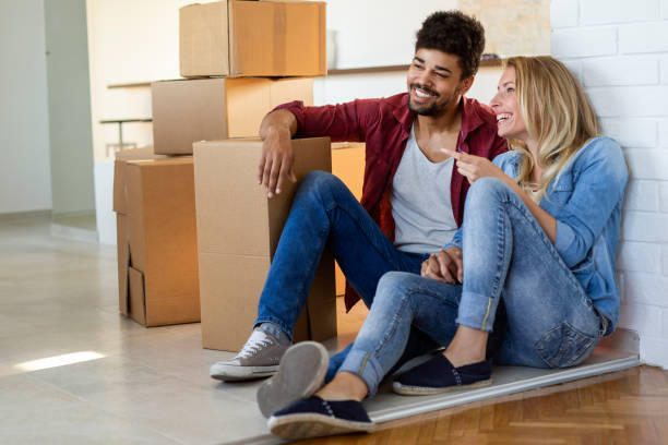 istock Young happy couple moving in new home and unpacking boxes 1148796991