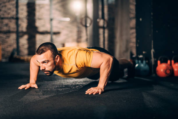 istock Young male athlete doing push ups workout in a gym 1148797066