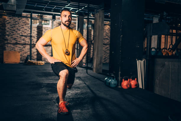 istock Muscular sporty young man doing a lunge exercise in a gym 1148797070