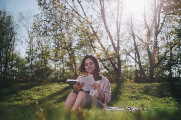 istock Cheerful Brunette Student Reading at the Park 1148798141