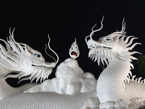 White dragon sculpture spilling water in a lake pond