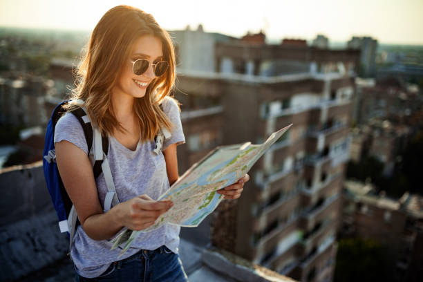 istock Happy young woman with a city map and a backpack travelling 1148798298