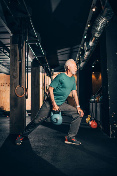 istock Active elderly male doing a one arm kettlebell exercise in a gym 1148798518
