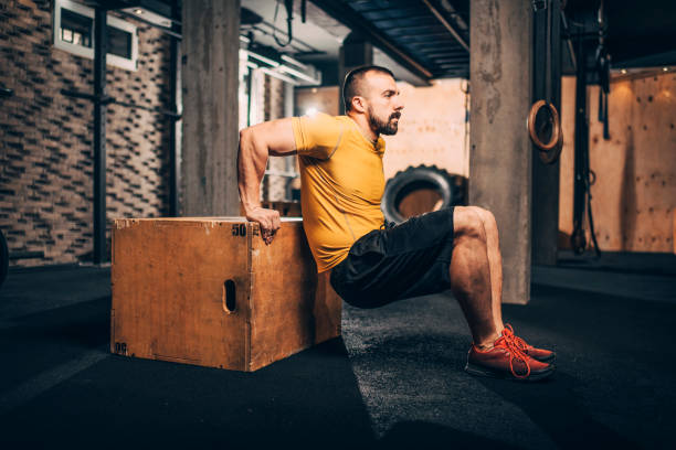 istock Buff male athlete doing dips workout on a box in a gym 1148798645