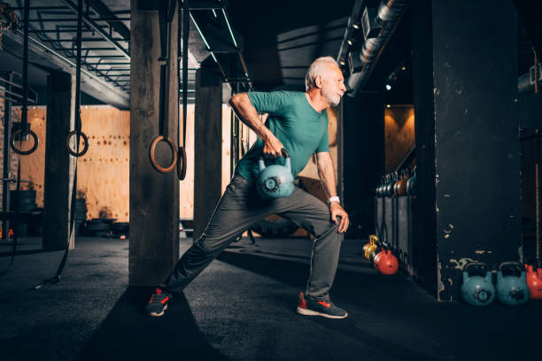 istock Active elderly male doing a one arm kettlebell exercise in a gym 1148799148