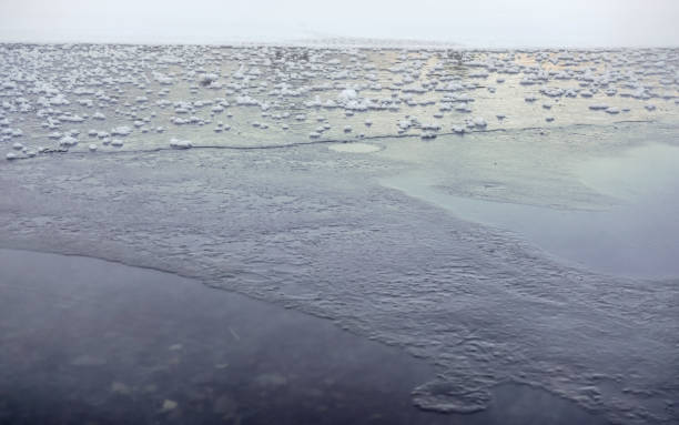 glace sur le lac gelé/étang, petites taches de neige sur la surface plane - snowpack photos et images de collection