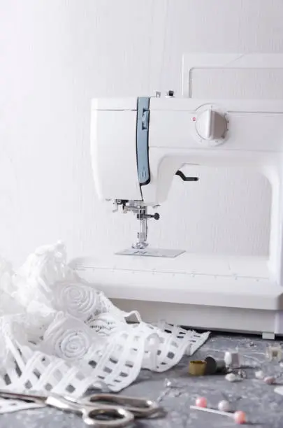 Concept of developing fashion collection. Sewing machine on the table and lot of sewing tools
