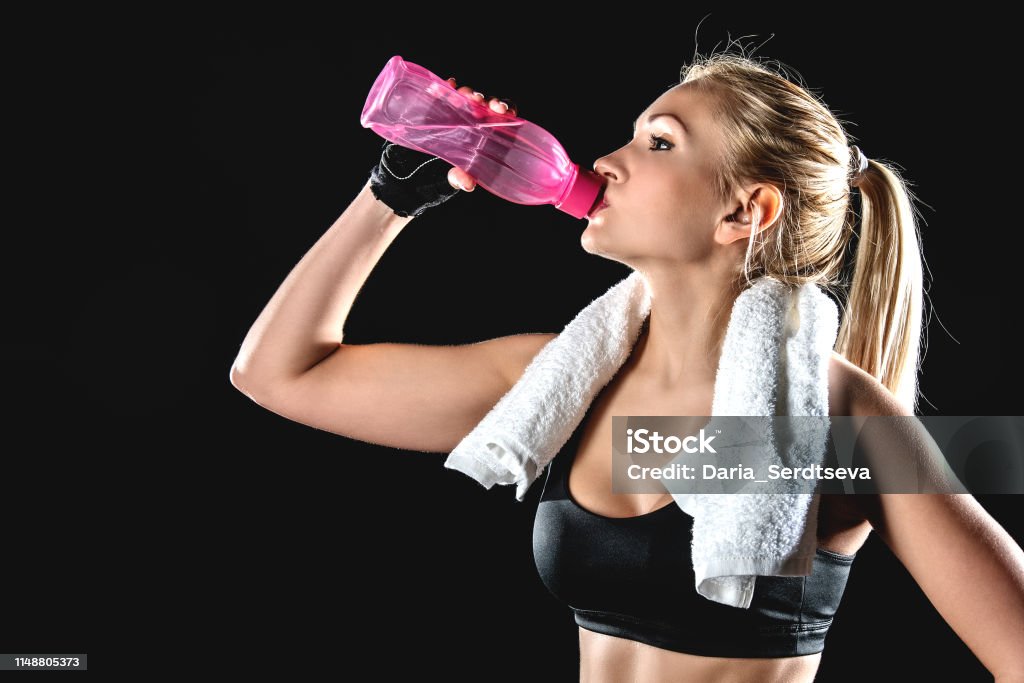 Athlete drinks water after exercise. Adult Stock Photo