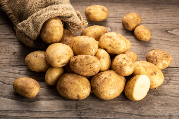 new potatoes on wooden background. - raw potato vegetable white raw imagens e fotografias de stock