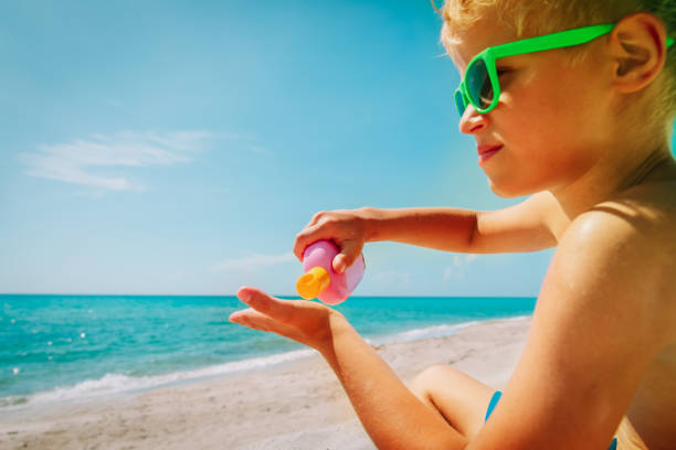 istock sun protection- happy boy with suncream at beach 1148808929