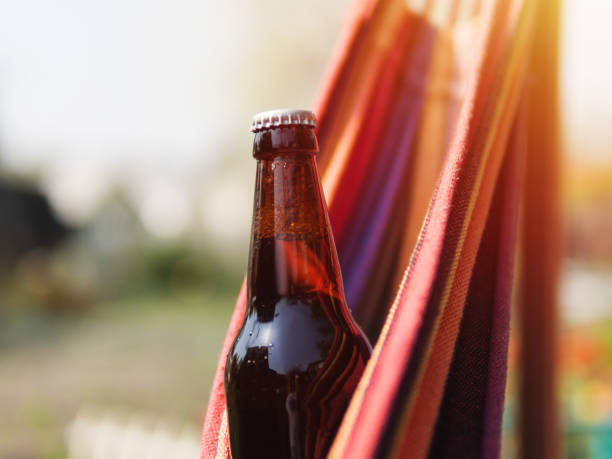 istock Closed chilled beer bottle on summer background. Hot sunny day 1148809710